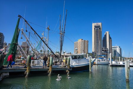 January 10, 2016 Corpus Christi, Texas, USA: fishermen selling daily catch form  boats at the docks with downtown in the backgroundのeditorial素材