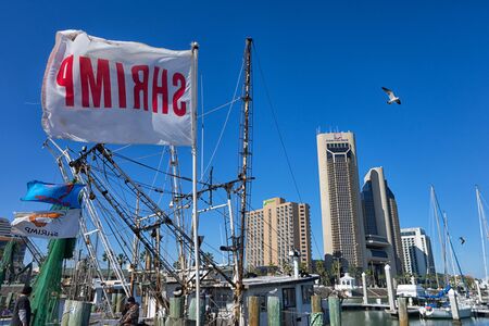 January 10, 2016 Corpus Christi, Texas, USA: flags fly on shrimping boats at the docks with downtown in the backgroundのeditorial素材
