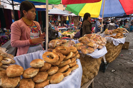 Otavalo, Ecuador - January 13, 2018: indigenous quechua women selling bakery products in the Saturday farmer's marketのeditorial素材
