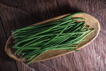 chinese yard-long green beans closeup in a wooden bowl