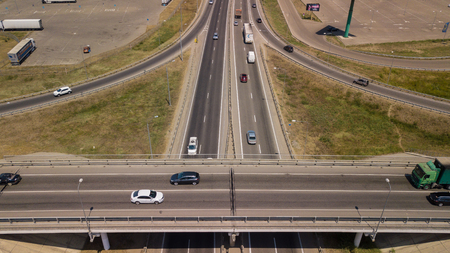 Summer aerial drone footage of transport junction, traffic cross road junction day view from above with green tree circle road, near is a wheat field. Top down view of traffic jam.のeditorial素材