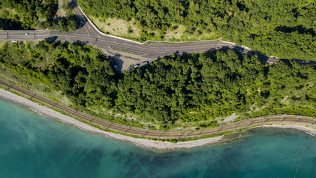 aerial view car driving along the winding mountain pass road through the forest in Sochi, Russia. People traveling, road trip on curvy road through beautiful countryside scenery.の写真素材