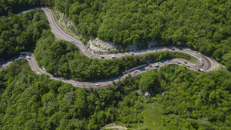 Winding road from the high mountain pass in South Russia. Great road trip trough the dense woods....