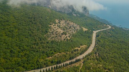 Crimean roads: aerial view of curvy mountain road in summer dayの写真素材