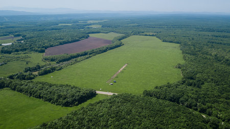 Aerial landscape nature - Dense green forest, green meadows, blue sky in southern Russiaの写真素材