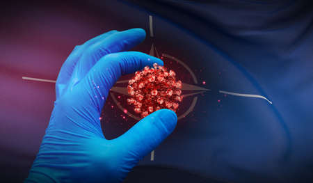 A hand in a medical glove holds a molecule, medical science concept, on background flag of NATO. 3D illustration.のeditorial素材