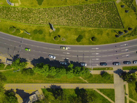 Aerial view at junctions of city highway. Vehicles drive on roads.
