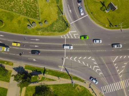 Aerial view at junctions of city highway. Vehicles drive on roads.