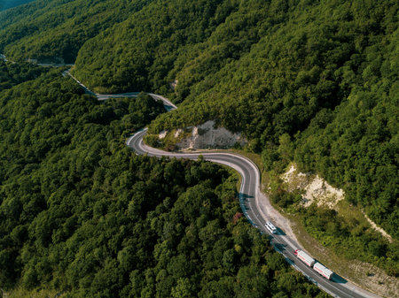 Mountain winding zig zag road. Top aerial view: cars driving on road from above.