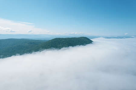 Flying through the clouds above mountain tops. High peaks wonderful morning sunrise natural Landscapeの写真素材