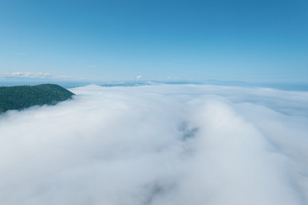 Flying through the clouds above mountain tops. High peaks wonderful morning sunrise natural...