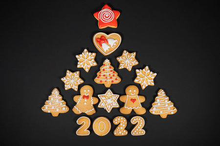 Christmas tree made from gingerbread cookies on dark black background with copy space for text....