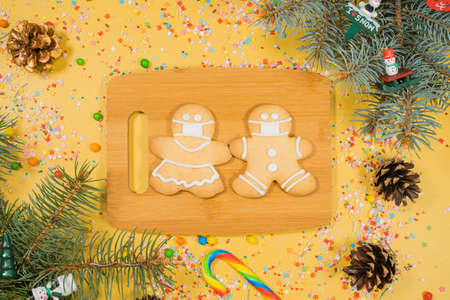 Christmas of gingerbread in mask, on cooking board in different shapes on yellow surface. Flat lay, top view.の写真素材