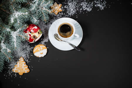 Christmas and New Year decoration composition. Top view of fur-tree branches on dark background with place for your text. Cups of fragrant coffee with marshmallows, gingerbread and chokolate.の写真素材