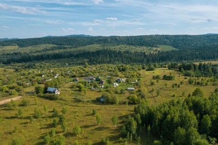 Aerial Landscape: summer mountain village with forests, fields, human settlement in Bashkortostan....