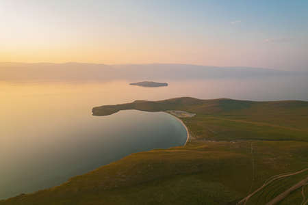 Olkhon Island at sunrise, the largest island in Lake Baikal in eastern Siberia. Shamanka Rock on Baikal lake near Khuzhir at Olkhon island in Siberia, Russia.の写真素材
