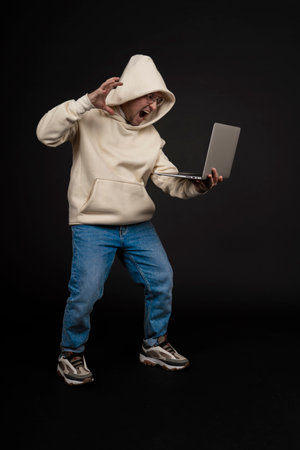 Young happy businessman with a notebook isolated on black background. Selective focus, main subject - man. Interesting business concept.の写真素材