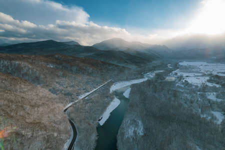 Aerial view of Plateau Lago-Naki mountain twisted road in the winter and driving car. Epic, snowy white winter and snow capped forest.の写真素材