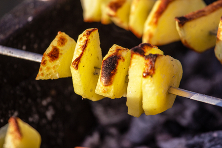 Assorted delicious grilled meat with vegetables over the coals on a barbecueの写真素材