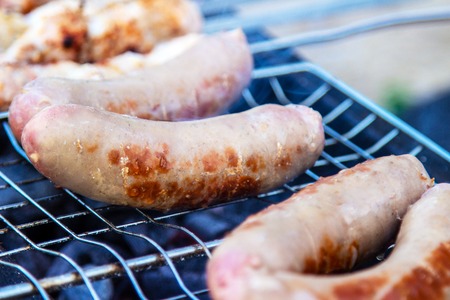 Assorted delicious grilled meat with vegetables over the coals on a barbecueの写真素材