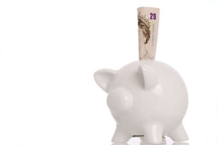piggy bank with british twenty pound note in slotの写真素材