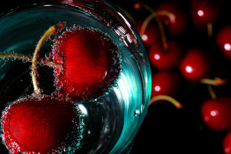cherries in a drink with bubblesの写真素材