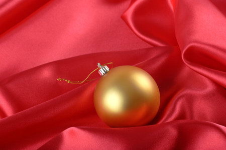 christmas bauble on a red silk fabric backgroundの写真素材