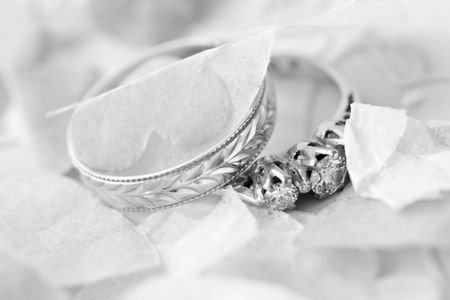 wedding ring and engagement ring surrounded by confettiの写真素材