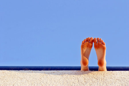 feet taking a rest in the hot summer sunshineの写真素材