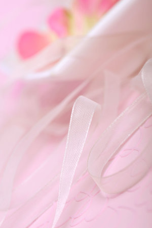  scented rose petal water in a bowl decorated with layers of lace ribbon. Focus on ribbon.の写真素材