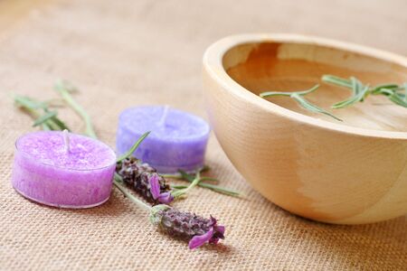 freshly cut lavender in old weathered wooden bowl with lavender scented candlesの写真素材