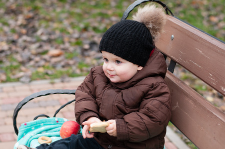 baby boy walks on nature in autumn city parkの写真素材