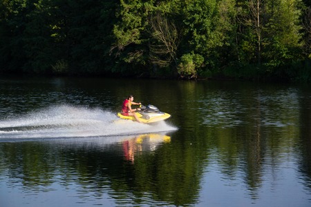 Ukraine, Sednev, the river Snov August 15, 2015: sports man riding a water bike, jet ski. Extreme sports, tourism, healthy lifestyleのeditorial素材