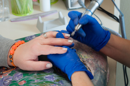 Apparatus manicure for a middle-aged woman. Cleaning the nails in the spa salon.の写真素材