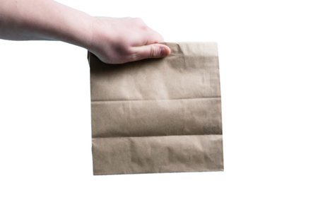 Craft bag in hand with takeaway food on white background isolate copy space. Concept of delivery,...