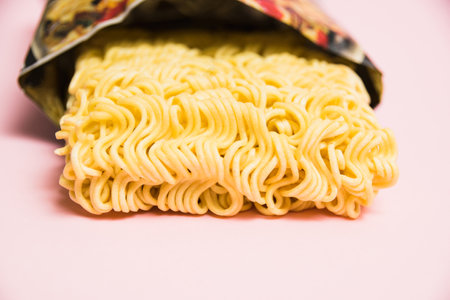 Instant noodles in a package on a pink background close-upの写真素材