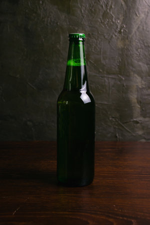 Aromatic beer in a glass bottle on a dark background.の写真素材