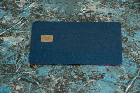 Modern bank credit card with chip on dark background.