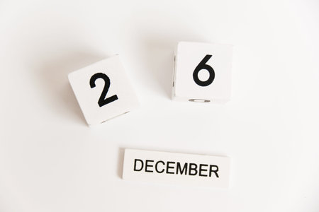 Wooden calendar with the date December 26 on a white background. The concept of preparing for the...