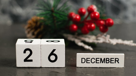 Wooden calendar with December 26 date and beautiful Christmas decoration on dark textured background with copy space.の写真素材