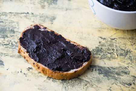 A tasty and nutritious snack of white bread with chocolate paste on a light background. Concept of calories and junk food.の写真素材
