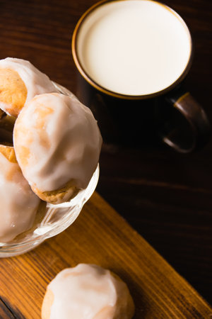 Delicious homemade gingerbread cookies with honey, cinnamon and vanilla in a glass bowl and a cup of hot milk on a dark background.の写真素材