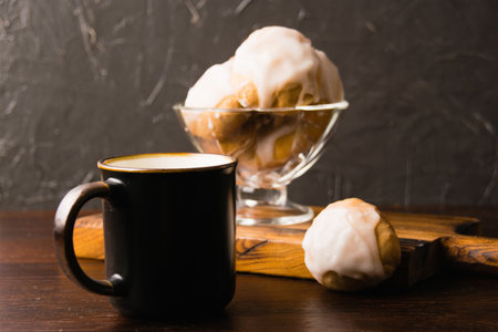 Delicious homemade cookies with honey, cinnamon and vanilla in a glass bowl and a cup of hot milk on a dark background.の写真素材
