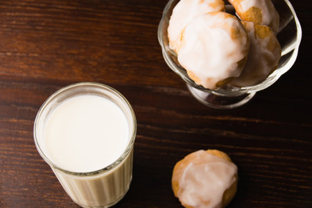 Delicious homemade gingerbread cookies with honey, cinnamon and vanilla in a glass bowl and a glass of hot milk on a dark background.の写真素材