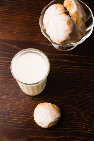 Homemade gingerbread cookies with honey, cinnamon and vanilla in a glass bowl and a glass of milk on a dark background.の写真素材