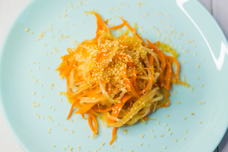 Delicious Korean cuisine. Salad with carrots and daikon Korean style on a beautiful turquoise plateの写真素材