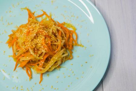 Delicious cuisine. Salad with carrots and daikon style on a beautiful turquoise plateの写真素材