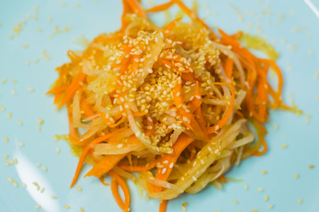 Delicious Korean cuisine. Salad with carrots and daikon Korean style on a beautiful turquoise plateの写真素材