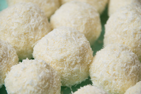 Delicious homemade candies with almonds and coconut flakes. Candies close-up macro on a light...