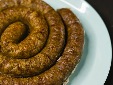 Delicious baked homemade sausage on a plate on a dark background, preparation for celebrating Easter in the family.の写真素材
